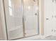 Bathroom shower with glass door, built-in seat, and white tile, offering a clean and modern design at 205 Purslane Dr, Franklinton, NC 27525