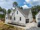 Side view of a white home with an attached carport and well-maintained landscaping, nestled in a wooded area at 205 Purslane Dr, Franklinton, NC 27525