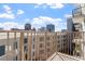 Condo balcony with a light-colored metal railing overlooking the city skyline and blue sky with white clouds at 222 Glenwood Ave # 508, Raleigh, NC 27603