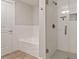 Bathroom featuring a glass shower, a soaking tub, and tiled flooring at 222 Glenwood Ave # 508, Raleigh, NC 27603