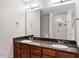 Bathroom with double sink vanity, granite countertops, and a glass-enclosed shower at 222 Glenwood Ave # 508, Raleigh, NC 27603