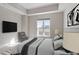 Staged bedroom with modern furniture, gray walls and view out window at 222 Glenwood Ave # 508, Raleigh, NC 27603