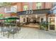 Front condo facade with a cafe featuring outdoor seating, covered entry with building number, and street views at 222 Glenwood Ave # 508, Raleigh, NC 27603