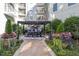 Condo common area with a pergola over a dining table and outdoor seating, mature plantings, and manicured landscaping at 222 Glenwood Ave # 508, Raleigh, NC 27603