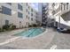 Condo community pool and patio area with lounge seating, deck, and shallow clear water surrounded by condos at 222 Glenwood Ave # 508, Raleigh, NC 27603