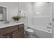 Bright bathroom features a tub with shower, tile floors, and a wooden vanity with a white countertop at 35 Diamond Creek Dr, Zebulon, NC 27597