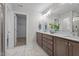 Bathroom featuring double vanity sinks, modern lighting fixtures, and elegant marble-patterned floors at 35 Diamond Creek Dr, Zebulon, NC 27597