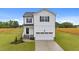 Two-story home showcasing a white exterior, black shutters, and a neatly manicured lawn on a sunny day at 35 Diamond Creek Dr, Zebulon, NC 27597