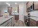 Well-lit kitchen featuring stainless steel appliances, granite countertops, dark wood cabinets, and a kitchen island at 35 Diamond Creek Dr, Zebulon, NC 27597