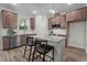 Modern kitchen boasts stainless steel appliances, granite countertops, dark wood cabinets, and an island with seating at 35 Diamond Creek Dr, Zebulon, NC 27597