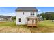 Rear exterior view of a white two-story house with a wooden porch and a well-maintained lawn at 35 Diamond Creek Dr, Zebulon, NC 27597