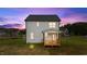Rear exterior view of a white two-story house with a wooden porch and a well-maintained lawn at 35 Diamond Creek Dr, Zebulon, NC 27597