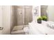 Well-lit bathroom featuring tiled shower with glass door, modern sink and decorative elements at 111 Johnson Ridge Way, Four Oaks, NC 27524