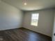 This bedroom features dark hardwood floors and a window that provides natural light at 111 Johnson Ridge Way, Four Oaks, NC 27524