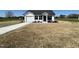 A single-story home features a driveway leading to an attached garage, surrounded by a spacious green space at 111 Johnson Ridge Way, Four Oaks, NC 27524