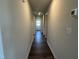 Long hallway with wood-look flooring, neutral walls, and an entrance door at the end at 111 Johnson Ridge Way, Four Oaks, NC 27524
