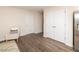 A bright living area with modern floors, featuring a cozy chair and convenient closet and refrigerator access at 111 Johnson Ridge Way, Four Oaks, NC 27524