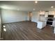 Open-concept living room with wood-look flooring and access to a modern kitchen at 111 Johnson Ridge Way, Four Oaks, NC 27524