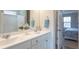 Bright bathroom with double sinks, marble counters, and a view into the main bedroom at 259 Johnson Ridge Way, Four Oaks, NC 27524