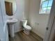 Cozy half bathroom featuring a pedestal sink and wood-look floors at 259 Johnson Ridge Way, Four Oaks, NC 27524