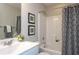 Bright bathroom featuring a shower-tub, stylish shower curtain, framed art, and decorative accents on the counter at 259 Johnson Ridge Way, Four Oaks, NC 27524