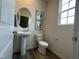 Bright half bathroom featuring a pedestal sink, framed art, and a window at 259 Johnson Ridge Way, Four Oaks, NC 27524