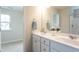 Bright bathroom with double vanity featuring elegant fixtures and a large mirror, providing a luxurious and functional space at 259 Johnson Ridge Way, Four Oaks, NC 27524