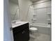 Well-lit bathroom featuring a modern vanity and tub/shower combination with gray tile floors at 259 Johnson Ridge Way, Four Oaks, NC 27524