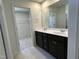 Modern bathroom featuring a double vanity, sleek cabinets, and a walk-in closet at 259 Johnson Ridge Way, Four Oaks, NC 27524