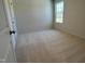 Neutral bedroom featuring carpet floors, a window for natural light, and a door at 259 Johnson Ridge Way, Four Oaks, NC 27524