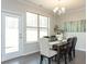 Dining room featuring a modern table, chairs, chandelier, a large window, and a door to the outside at 259 Johnson Ridge Way, Four Oaks, NC 27524