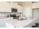 Bright kitchen features white cabinets, stainless steel appliances, granite countertops, and a large island at 259 Johnson Ridge Way, Four Oaks, NC 27524