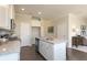 Open kitchen boasts white cabinets, stainless steel appliances, granite countertops, and a view to the living room at 259 Johnson Ridge Way, Four Oaks, NC 27524