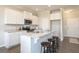 Bright kitchen features white cabinetry, granite countertops, stainless appliances, and breakfast bar seating at 259 Johnson Ridge Way, Four Oaks, NC 27524