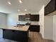 Modern kitchen with dark cabinets, granite countertops, and stainless steel appliances at 259 Johnson Ridge Way, Four Oaks, NC 27524