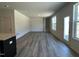 Spacious living room featuring neutral walls, wood-look floors, and natural light from windows and a glass door at 259 Johnson Ridge Way, Four Oaks, NC 27524