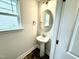 Stylish powder room with pedestal sink, modern fixtures, and a window for natural light at 320 Bishop Ln, Sanford, NC 27330