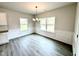 Dining area with hardwood floors, modern chandelier, and ample natural light from large windows at 320 Bishop Ln, Sanford, NC 27330