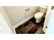 Well-lit powder room featuring a white toilet and dark tile floors for a modern and clean appearance at 320 Bishop Ln, Sanford, NC 27330
