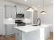 Modern kitchen with island, white cabinets, and gold pendant lights at 3939 Willow Gate Way, Knightdale, NC 27604