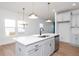 Modern kitchen island with white quartz countertops and stainless steel appliances at 3939 Willow Gate Way, Knightdale, NC 27604