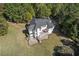 Aerial view of a white house featuring a large deck and patio perfect for outdoor entertaining at 488 Colvard Farms Rd, Durham, NC 27713