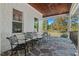 View of a relaxing covered patio with stone floor, wooden ceiling, and wrought iron furniture at 488 Colvard Farms Rd, Durham, NC 27713