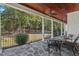 View of a covered porch with a stained wood ceiling, ceiling fan, and wrought iron seating overlooking the yard at 488 Colvard Farms Rd, Durham, NC 27713