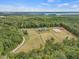 Stunning aerial view of estate featuring a large home, horse paddocks and a winding driveway at 548 Double N Rd, Pittsboro, NC 27312