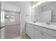 Modern bathroom features double vanity, quartz countertops, and a view into the adjacent bedroom at 1829 Hydrangea Way, Fuquay Varina, NC 27526