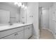 Bright bathroom with double sinks, white cabinetry, and a glass-enclosed shower at 1829 Hydrangea Way, Fuquay Varina, NC 27526