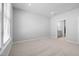 Neutral bedroom boasts plush carpeting, neutral walls, and an open doorway with a bathroom vanity visible at 1829 Hydrangea Way, Fuquay Varina, NC 27526