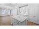 Open concept kitchen features a granite island, white cabinets, stainless steel appliances, and wood flooring at 1829 Hydrangea Way, Fuquay Varina, NC 27526