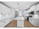 Beautiful, bright open kitchen featuring white cabinets, granite counters, a kitchen island, and modern appliances at 1829 Hydrangea Way, Fuquay Varina, NC 27526